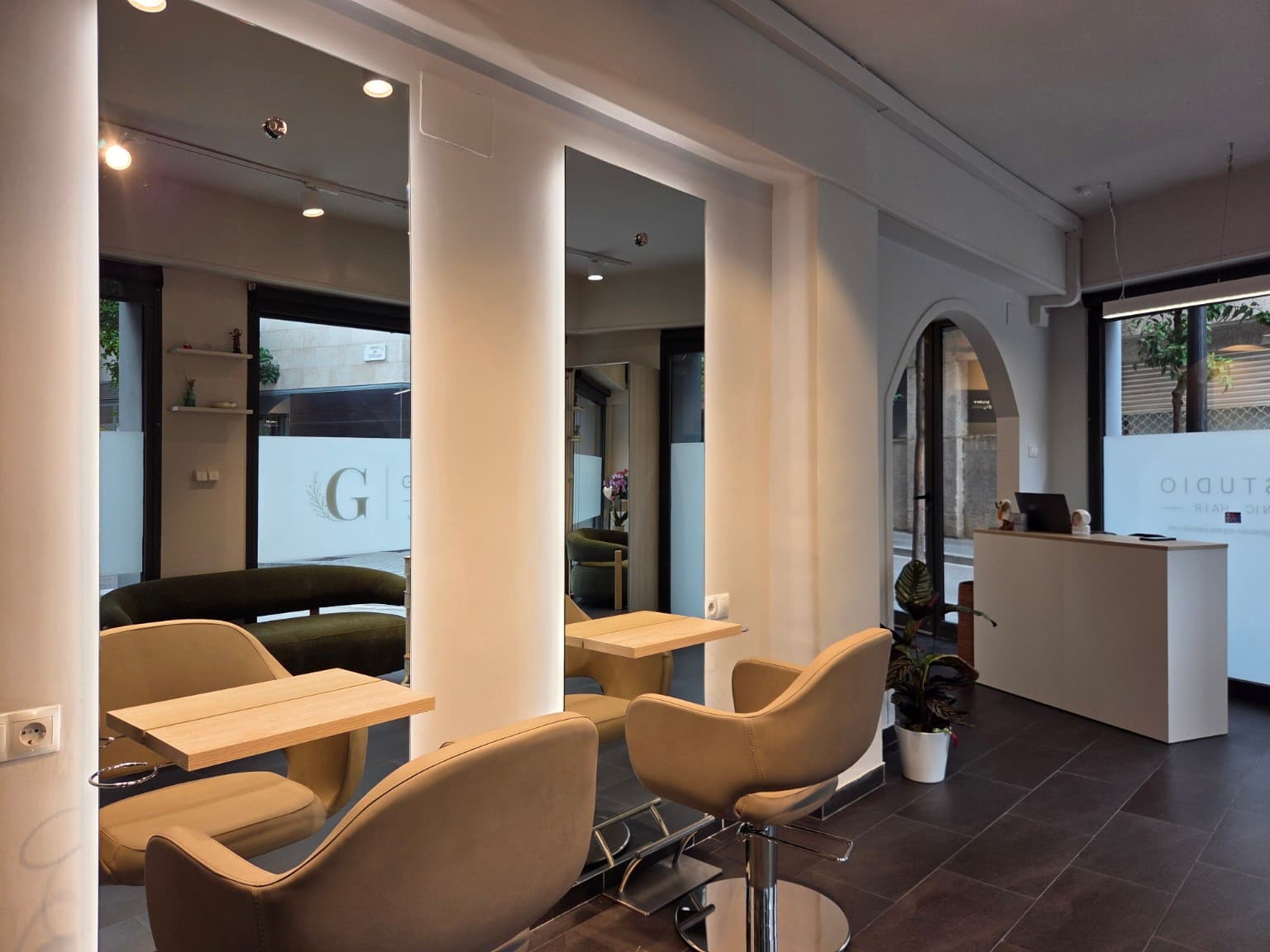 Puestos de peinado con sillones beige y espejos en Gio Studio